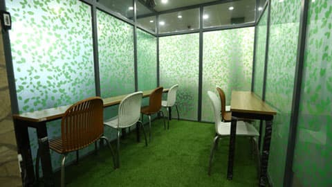Glass-walled breakout booths with turf flooring